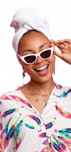 positive dark skinned woman dressed smiling with sunglass